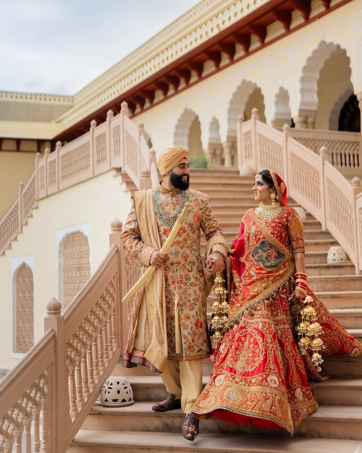 A bride and groom walking together on a palace staircase